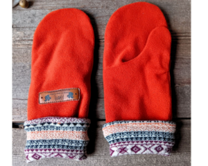 A cozy pair of teen, small woman’s handmade mittens crafted from soft rust orange fleece with patterned cuffs; handmade & winter ready.