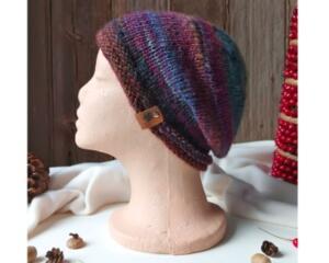 A hand knit wool & acrylic beanie in an ombre purple and blue cozy stitch pattern. For winter holiday gifting for kids ages 6, 7, 8, 9.