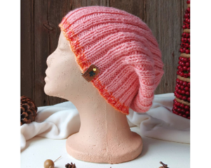 A hand knit pink wool beanie with a ribbing stretchy stitch pattern. For children and preteens ages 10, 11, 12, 13, 14.