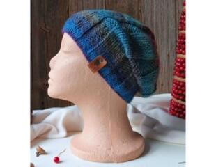 A hand knit wool & acrylic beanie in an ombre blue and purple cozy stitch pattern. For winter holiday gifting for kids ages 6, 7, 8, 9.