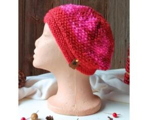 A hand knit red acrylic beanie in a textured stitch pattern. For winter holiday gifting for kids ages 6, 7, 8, 9.
