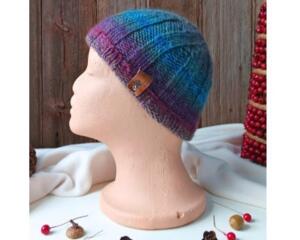 A side view of a handmade baby hat in a blue & purple wool blend yarn. Great for winter holiday gifting for newborn babies 0 to 12 months.