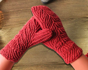 A pair of hand knit mittens with vine like pattern, sized for kids ages 8, 9, 10 years old. Perfect as a cold winter holiday gift for kids.