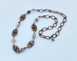 Handmade choker necklace with faceted aquamarine, lilac crystals, and copper links attached to a copper chain with handmade hook clasp.