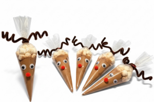 Set of five handmade reindeer hot cocoa cones with homemade cocoa mix displayed on a white background