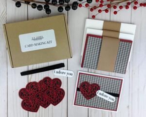 A valentine card kit with black and gray houndstooth paper and red and black heart embellishments to make 6 handmade valentine cards.