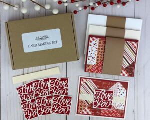 A handmade card kit to DIY 6 cards. The kit contains red scrapbook paper with a quilt design, die cut embellishments and ribbon.