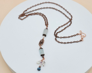 Handmade aquamarine and copper lariat necklace with vertical drop, natural gemstone beads, and a copper chain with hook clasp.