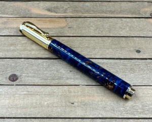 Gold rollerball pen with blue resin and pinecones 