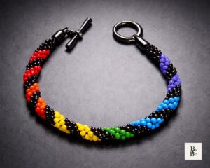 Rainbow Helix One Spectrum Pride Kumihimo bracelet by Bead & Braid Collective, handmade spiral rainbow beaded design on a dark background