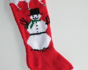 Snowman with green scarf on red and white hand knit Christmas stocking, personalized at top, and embellished with silver bells.