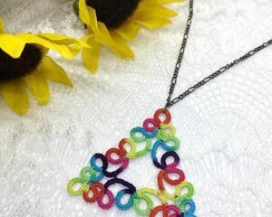 Rainbow colored triangle shaped pendant on dark chain