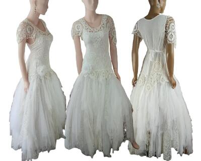 White long, tulle and crochet wedding dress. Tie up back for a snug waist fit. Asymmetrical sleeves with a large white flower on the right hip. One of a kind, handmade, eco-friendly, bohemian style dress.