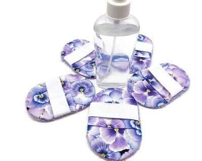 reusable eco-friendly make up removal pads, set of 5 pads, with mesh laundry bag included.  Blue and lavender pansies on a white background, with lavender terry cloth on opposite side.  Elastic for you hand.  They measure 3 by 4 1/2 inches.  Use with your favorite make up remover or facial soap.  Machine wash in mesh bag, in warm or cold water.  Dry in dryer on low.  Handmade.