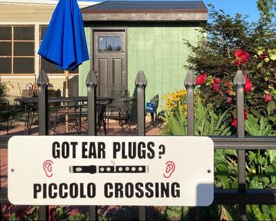 Yep, you have to have ear plugs if you live with a piccolo player. 
Everything is hand made except the aluminum sign.  All other items attached are designed and made by Flute Emporium. We used vinyl so sign could be used indoors or outdoors according to your wishes. There is a wood looking piccolo with keys, ears. and lots or wordage.