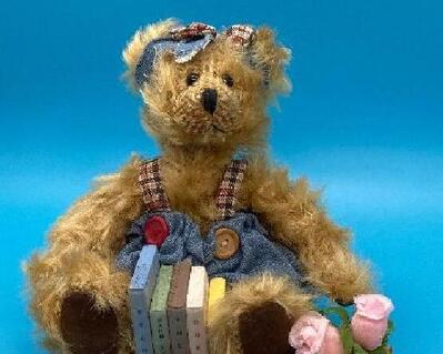 A female bear at home and seated with her school books.  She is a sturdy and strong-built bear with long fur in a light honey tone. Books are wood and have labels, fRoses in basket, and wearing a denin outfit with matching hair bow.. She is seated securely on a deep rose color plaque.Bear 4.5" H x 2.5" W  Wood Plaque 3" x 5" .  The only one like it in entire world!