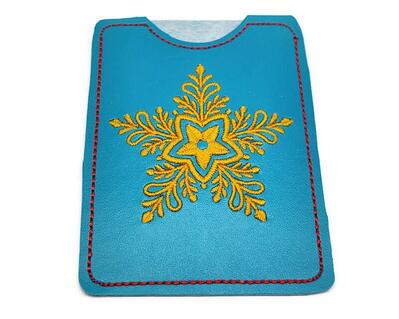 Let it snow, let it snow, let it snow.  This snowflake gift card holder can deliver your card gift to that special person without the snow.

    What You Get:  One vinyl, machine embroidered gift card holder.  Card holder is reusable.
    Fabrics Used:   Vinyl, polyester embroidery thread and tear away stabilizer.
    Fabric color:  The vinyl is a teal, with bright gold colored machine embroider thread.  The outline is done in red.  Each one is hand cut.
    Size:  3 1/4 x 4 1/4 inches.  Picture 3 shows size compared to my hand.
    Care:  Wipe with a damp cloth.