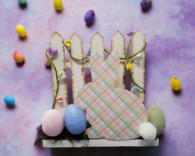Picket fence with a bunny sporting a sprint plaid print.