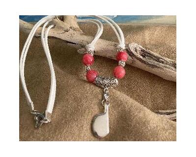 Pink large beads on a curved filigree bail and beads.  White faux suede  with heart clasp finalizes this item. This is a simple and beautiful necklace which can be worn year around.