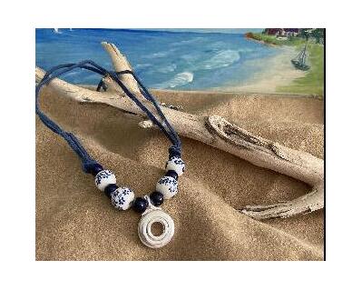 This necklace has large white beads with lovely blue flowers and navy bluye solid beards but, it is a larger version of the trill key necklace with flowers..  A Silver open hole flute key is the pendant of choice.