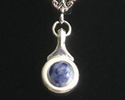 Beautiful Blue Jasper stone is viewed on a flute trill key.  A fleur de lis bail on a  16" silver plated snake chain.  Available in 10 stone choices that include s: coral, pastel green, pastel, pink ande more. Lovely small silver pendant that is wearable for leisure or dress.