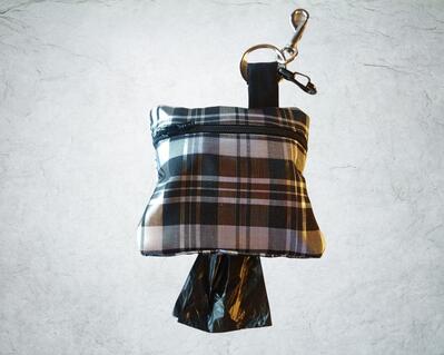Black and white plaid poop bag holder or treat bag . 4 x 4 inches and comes with a free roll of bags.  Zipper Close and clip to hold used bags.