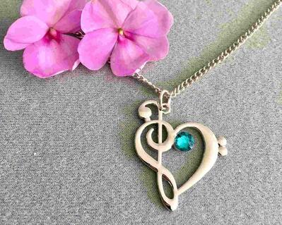 Stunning music necklace and is unisex.  A  heart is made by attaching a treble and bass clef into a contemporary design heart.  A  glass aqua stone adds to the beauty of this jewelry piece.