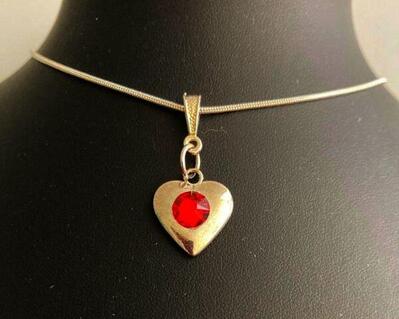 A dainty puff heart with a red crystals, silver bail, and silver plated chain.  This is  beautiful for a  young musicians birthday.  Simplistic and lovely.