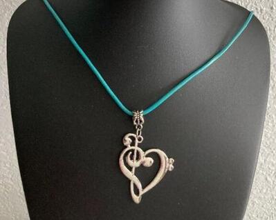 A  heart is made by attaching a treble and bass clef into a contemporary design heart.    A lovely gift for  women, musicians, students You have a choice of 3 leather cords for your necklace: turquoise, lime, and _pinkish