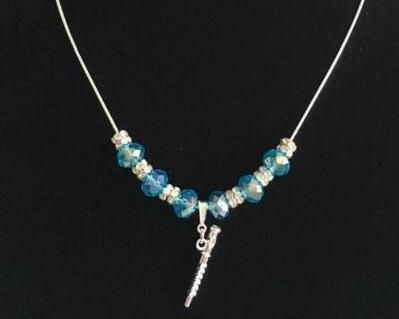 Elegant turquoise glass beads with double silver tone spacers  placed on a silver plated chain with a 3D flute pendant charm held by a silver bail.  A lovely gift for all ages and is  dainty and petite 
 for younger and older flutists.  Handmade and designed by Flute Emporium.
