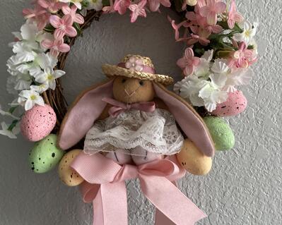 Cute and lovable all in one little bears with large cloth ears lined in pink fabric.  She is a jointed bear and fits the 8.5" wreath with lots of pink and white flowers and pink bows.  The wreath also has 6 Easter Eggs on each side of her.  HAPPY EASTER FROM FLUTE EMPORIUM!