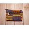Front view of  a golden yellow, green and blue zippered medium sized makeup pouch