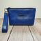 front view of a  blue marbled faux leather makeup bag with gunmetal hardware and a wristlet strap.