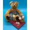 A female bear at home and seated with her school books.  She is a sturdy and strong-built bear with long fur in a light honey tone. Books are wood and have labels, fRoses in basket, and wearing a denin outfit with matching hair bow.. She is seated securely on a deep rose color plaque.Bear 4.5" H x 2.5" W  Wood Plaque 3" x 5" .  The only one like it in entire world!