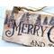 This is a close-up picture of wood-burned Christmas artwork. It shows Christmas trees and the word merry drawn in old-time lettering.