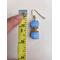 One blue earring lays on a table beside a measuring tape.  The earring measures 1.75 inches long.