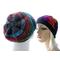 Mannequin in front shows off the gathered crown of a multicolor Spiriferous slouchy hat.  Mannequin in back is wearing the beanie version.