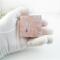 Handmade tiny copper trinket box with purple and green vine-rose pattern on lid and pink tourmaline october  gemstone cabochon shown in my gloved hand for size comparison