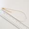 Skinny pearl choker, shown next to a ruler.
