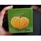 Photo of small square canvas painting of orange pumpkin with a olive green background