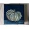 Photo of small square canvas painting of oddly shaped light blue pumpkin with a dark blue background