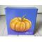 Photo of small square canvas painting of orange pumpkin with purple blue background