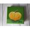 Photo of small square canvas painting of orange pumpkin with a olive green background
