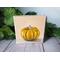 Photo of small square canvas painting of orange pumpkin with peach colored background