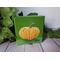 Photo of small square canvas painting of orange pumpkin with a olive green background