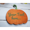 A wooden pumpkin magnet painted in a subdued shade of orange with a sage green curly stem. The same sage green is printed across the pumpkin and says "Your text here.."