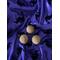3 light tan balls of soap sitting on top of purple fabric that is decorated with black velvet witches riding brooms.