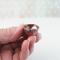 Tiny Copper Enamel bowl held by tips of fingers to show size reference