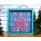 A pink and teal small shadow box with a wood very merry holly jolly Christmas tree