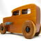 This handmade wooden toy car is based on a 1932 Ford Sedan Hot Rod. It is hand-finished with multiple coats of amber shellac and trimmed with black and grey acrylic paint.